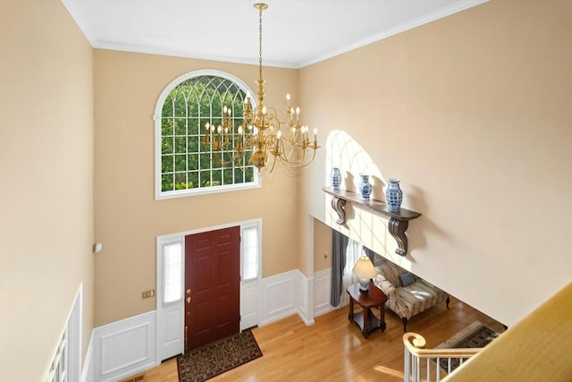 75 Kennedy Cir, Northbridge, MA 01534 - foyer entrance featuring wood finished floors, a chandelier, crown molding, a wainscoted wall, and a decorative wall