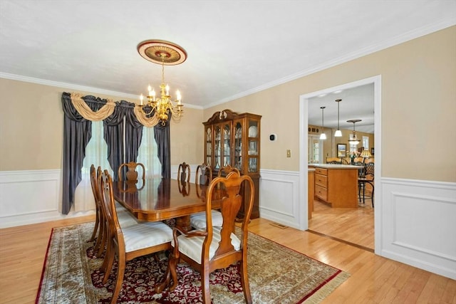 75 Kennedy Cir, Northbridge, MA 01534 - dining area featuring a chandelier, light wood-style flooring, a wainscoted wall, crown molding, and a decorative wall