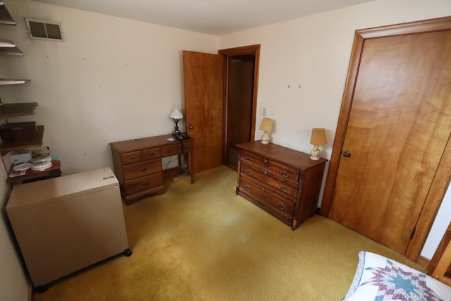 bedroom with fridge, visible vents, and light colored carpet