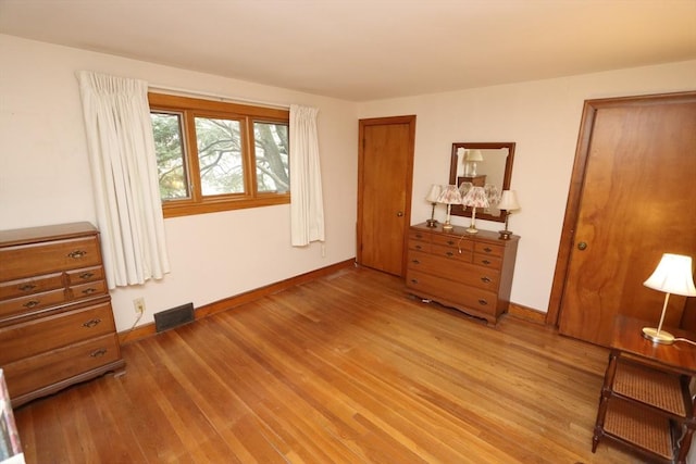 bedroom featuring visible vents, light wood-style flooring, and baseboards