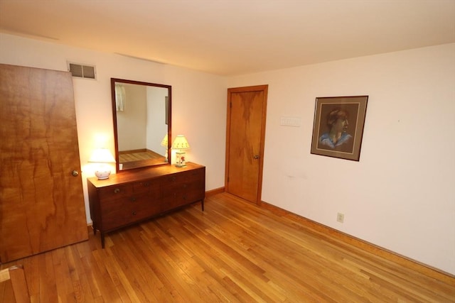 unfurnished bedroom with light wood finished floors, visible vents, and baseboards