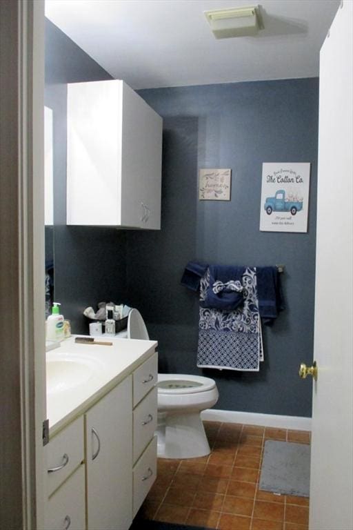 bathroom with toilet, vanity, and tile patterned floors