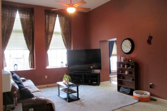 living room featuring ceiling fan, a healthy amount of sunlight, and light carpet