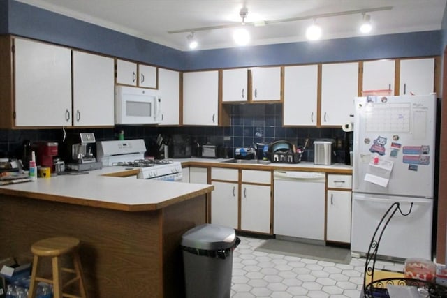 kitchen featuring white appliances, white cabinets, decorative backsplash, and kitchen peninsula