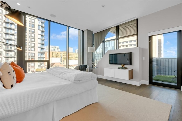 140 Shawmut Ave Unit 5A, Boston, MA 02118 - bedroom featuring multiple windows, access to outside, wood finished floors, and baseboards