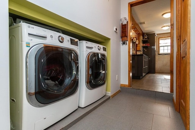 washroom featuring baseboards, tile patterned flooring, washing machine and dryer, visible vents, and laundry area