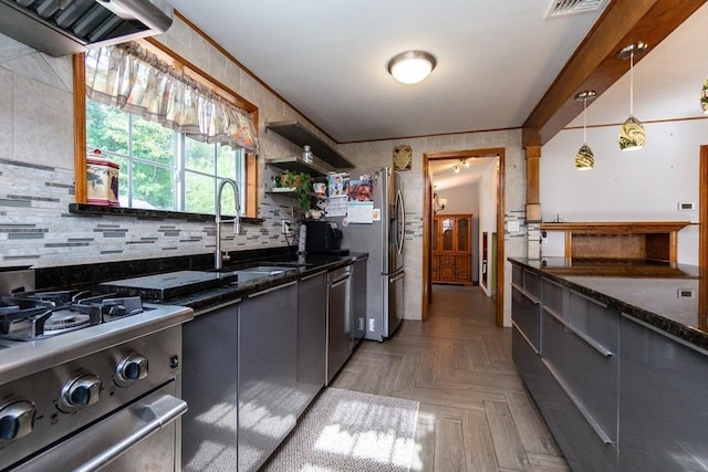 kitchen with tasteful backsplash, open shelves, dark stone countertops, a sink, and stainless steel appliances