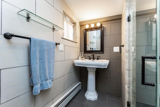 full bathroom featuring tile walls, tile patterned flooring, a stall shower, and a baseboard heating unit