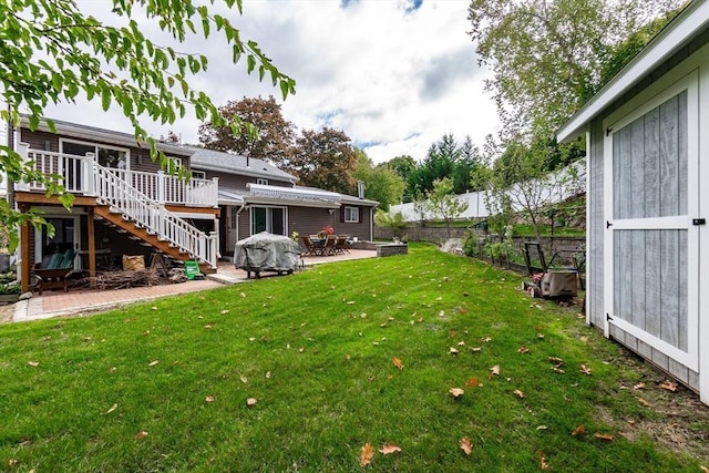 view of yard featuring a fenced backyard, a deck, a patio, and stairs