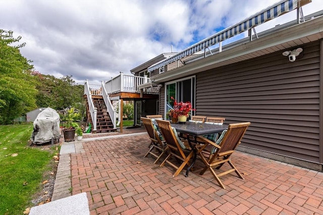 view of patio with stairway, outdoor dining area, and a wooden deck