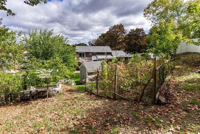 view of yard with a shed, fence, and an outbuilding