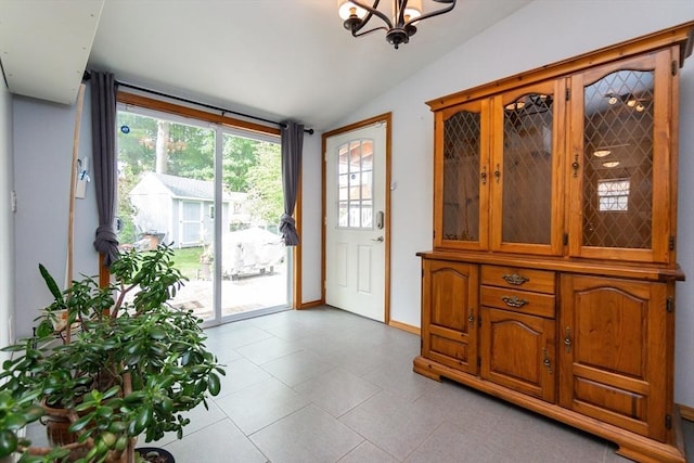 entryway featuring baseboards, light tile patterned floors, a notable chandelier, and vaulted ceiling