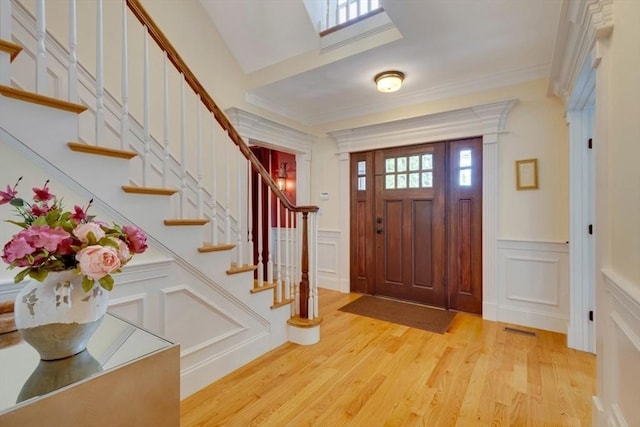 10 Damon Rd, Needham, MA 02494 - entrance foyer with a decorative wall, light wood-style flooring, stairway, a wainscoted wall, and crown molding