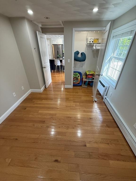 146 Main St Unit 2D, Clinton, MA 01510 - corridor featuring a wall unit AC, a baseboard radiator, recessed lighting, light wood-type flooring, and baseboards