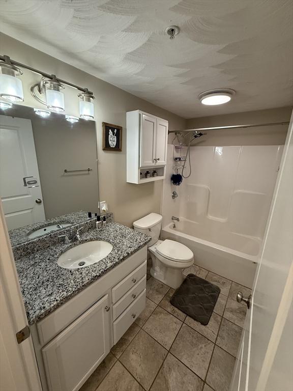 146 Main St Unit 2D, Clinton, MA 01510 - full bathroom featuring shower / washtub combination, toilet, vanity, and tile patterned floors
