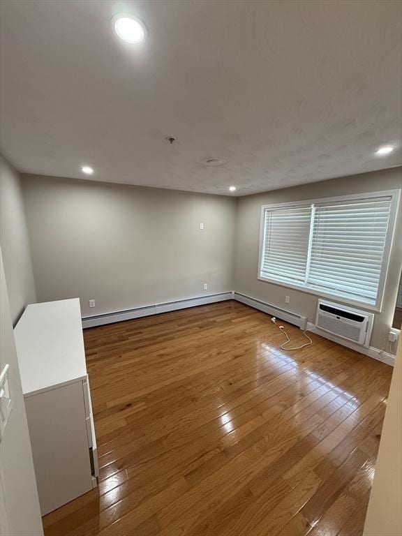 146 Main St Unit 2D, Clinton, MA 01510 - unfurnished room with a wall unit AC, wood-type flooring, a baseboard heating unit, and recessed lighting