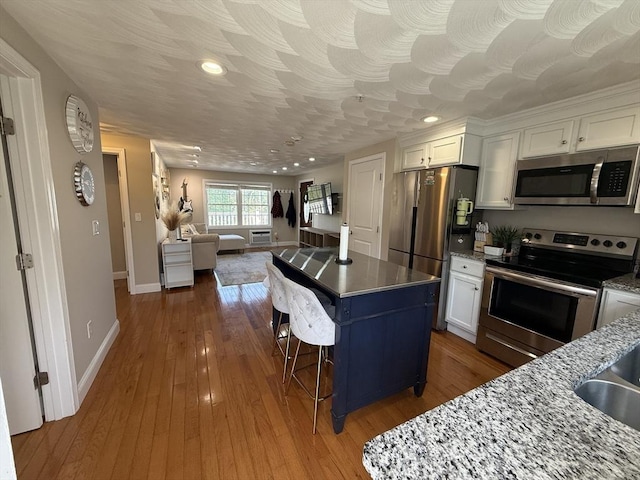 146 Main St Unit 2D, Clinton, MA 01510 - kitchen featuring appliances with stainless steel finishes, white cabinetry, a kitchen island, and recessed lighting
