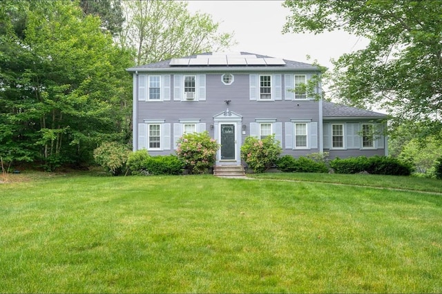 67 Raymond Rd, Plymouth, MA 02360 - colonial-style house with roof mounted solar panels, entry steps, and a front yard