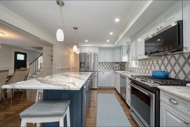 67 Raymond Rd, Plymouth, MA 02360 - kitchen with stainless steel appliances, white cabinets, decorative backsplash, light stone counters, and crown molding
