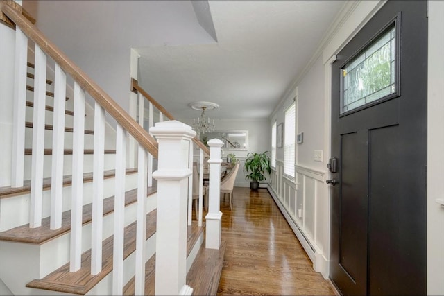 67 Raymond Rd, Plymouth, MA 02360 - entryway with a baseboard radiator, a chandelier, wood finished floors, stairway, and a decorative wall