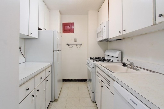 kitchen featuring white appliances, white cabinetry, light countertops, and a sink