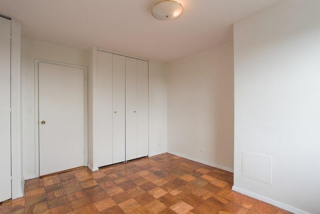 unfurnished bedroom with a closet and baseboards