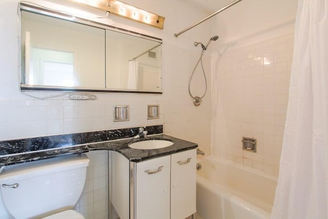 bathroom with visible vents, toilet, shower / bathtub combination with curtain, vanity, and tile walls