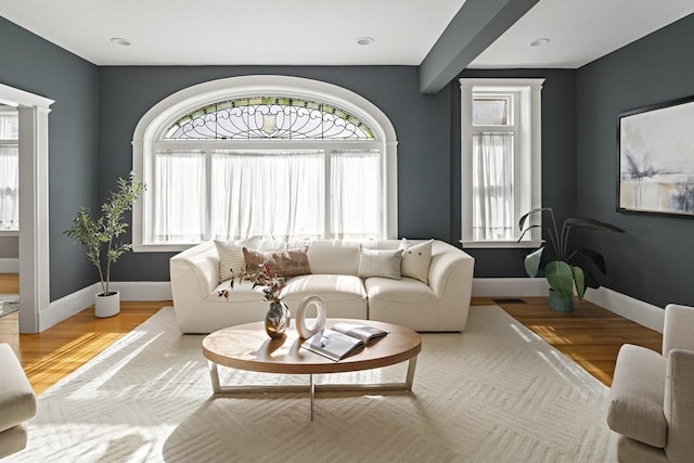 living room with visible vents, baseboards, and wood finished floors