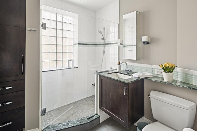 full bath featuring toilet, vanity, and a stall shower