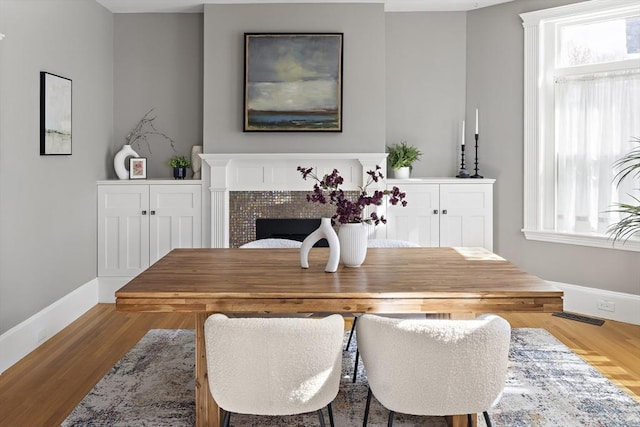 dining space with plenty of natural light, visible vents, baseboards, and wood finished floors