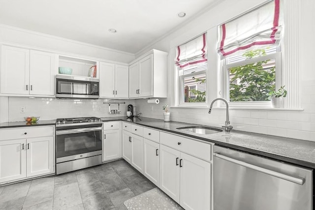 115 Westbourne Ter Unit 1, Brookline, MA 02446 - kitchen with stainless steel appliances, backsplash, dark countertops, white cabinets, and crown molding