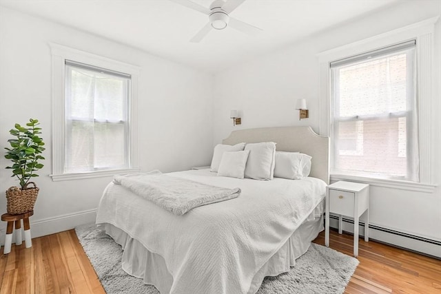 115 Westbourne Ter Unit 1, Brookline, MA 02446 - bedroom with multiple windows, light wood finished floors, baseboard heating, and ceiling fan