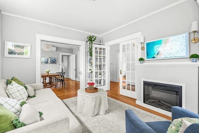 115 Westbourne Ter Unit 1, Brookline, MA 02446 - living room featuring wood finished floors, a glass covered fireplace, crown molding, and a chandelier