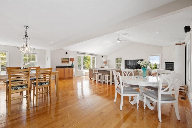 35 Beverly Hill Dr, Shrewsbury, MA 01545 - dining space featuring light wood-style flooring, a chandelier, vaulted ceiling, ceiling fan, and a large fireplace