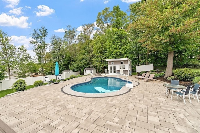 35 Beverly Hill Dr, Shrewsbury, MA 01545 - view of pool with an outbuilding, a patio area, fence, a storage unit, and view of wooded area