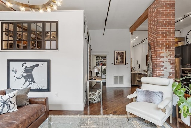 172-178 Green St Unit 1, Boston, MA 02130 - living area with washer and dryer, wood finished floors, baseboards, and a barn door