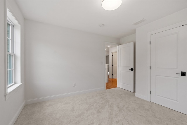 unfurnished bedroom featuring light carpet