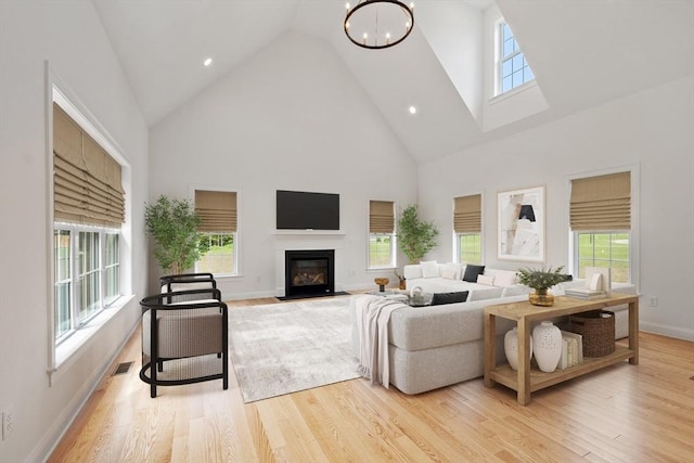 LOT16 Rawson Farm, Mendon, MA 01756 - living area featuring a notable chandelier, high vaulted ceiling, a fireplace with flush hearth, light wood-type flooring, and visible vents