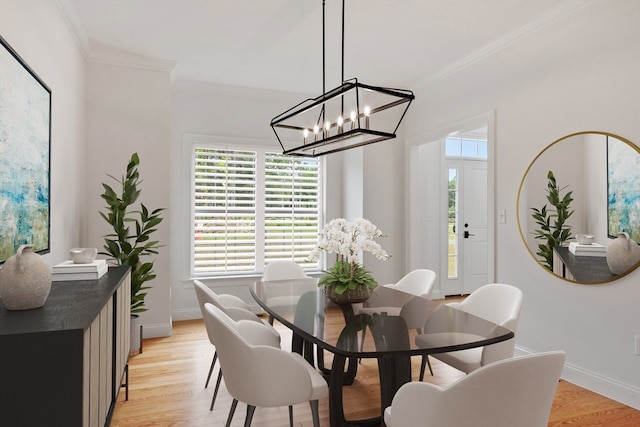 dining space with ornamental molding, light hardwood / wood-style floors, and an inviting chandelier