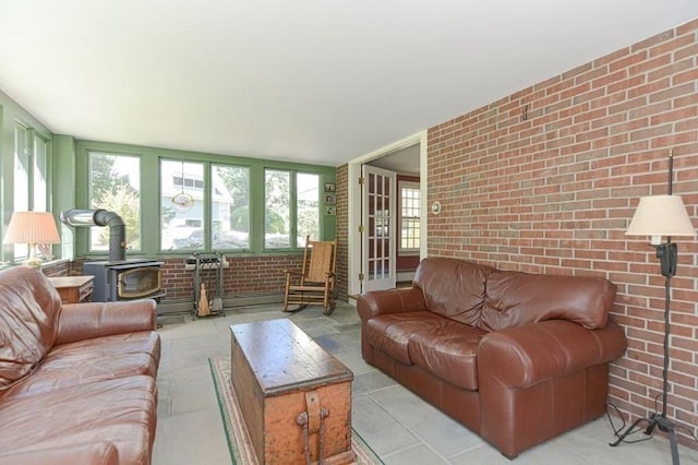 living room featuring brick wall and a wood stove