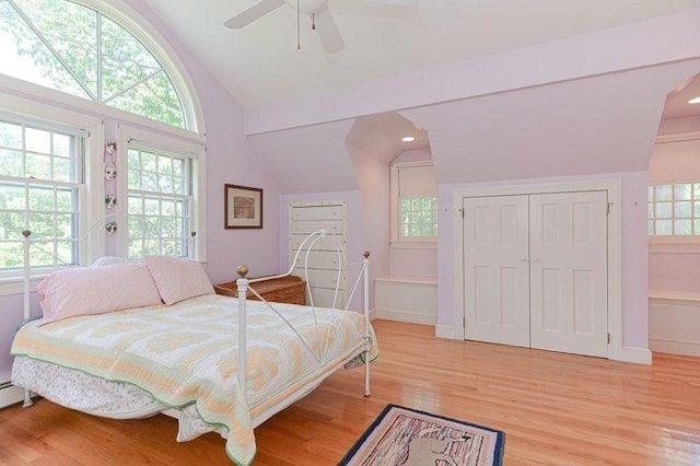 bedroom with multiple windows, lofted ceiling, and light wood-type flooring