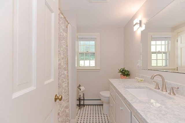 bathroom with vanity, toilet, and baseboard heating