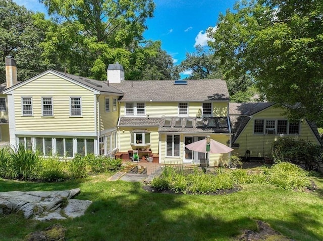 rear view of house featuring a balcony, a lawn, and a patio area