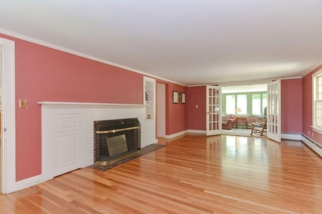 unfurnished living room featuring crown molding, light wood-type flooring, and french doors