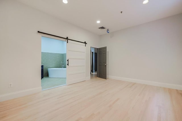 515 Centre St Unit 2, Newton, MA 02458 - empty room featuring a barn door, recessed lighting, wood finished floors, and baseboards