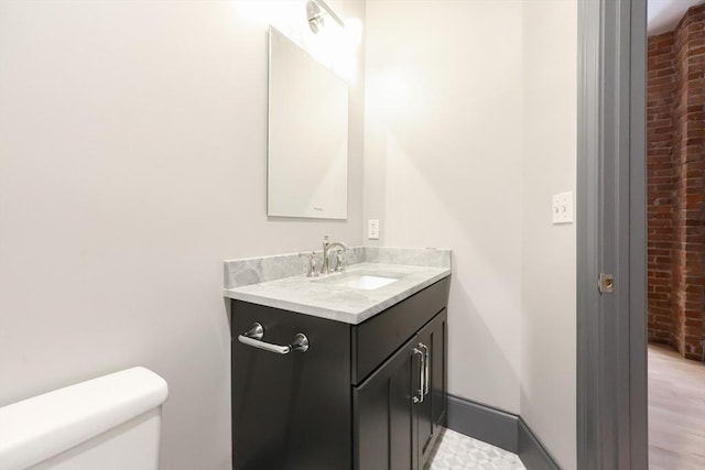 515 Centre St Unit 2, Newton, MA 02458 - half bath with brick wall, vanity, and toilet