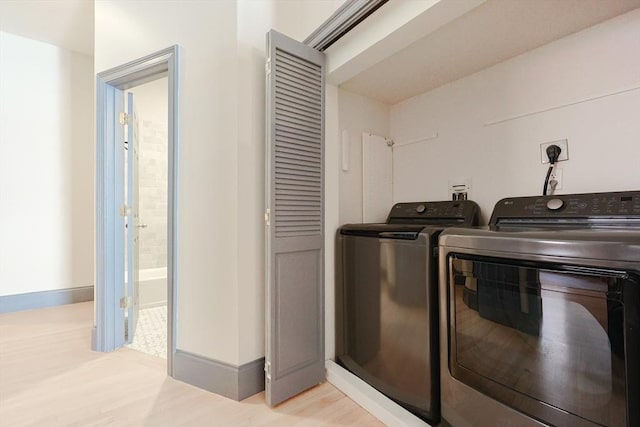 515 Centre St Unit 2, Newton, MA 02458 - washroom featuring washing machine and dryer, light wood-style flooring, and baseboards