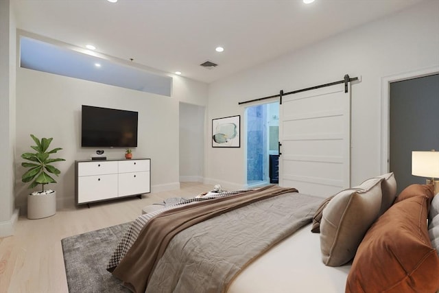 515 Centre St Unit 2, Newton, MA 02458 - bedroom with a barn door, light wood-style floors, recessed lighting, and baseboards