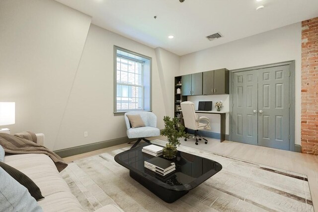 515 Centre St Unit 2, Newton, MA 02458 - living room with light wood finished floors, an office area, baseboards, recessed lighting, and brick wall