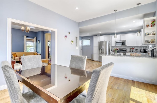 dining room featuring light wood-type flooring, recessed lighting, and a chandelier
